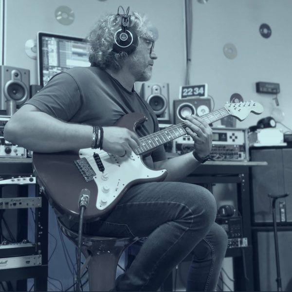 Chitarrista con Stratocaster rossa in sala di registrazione